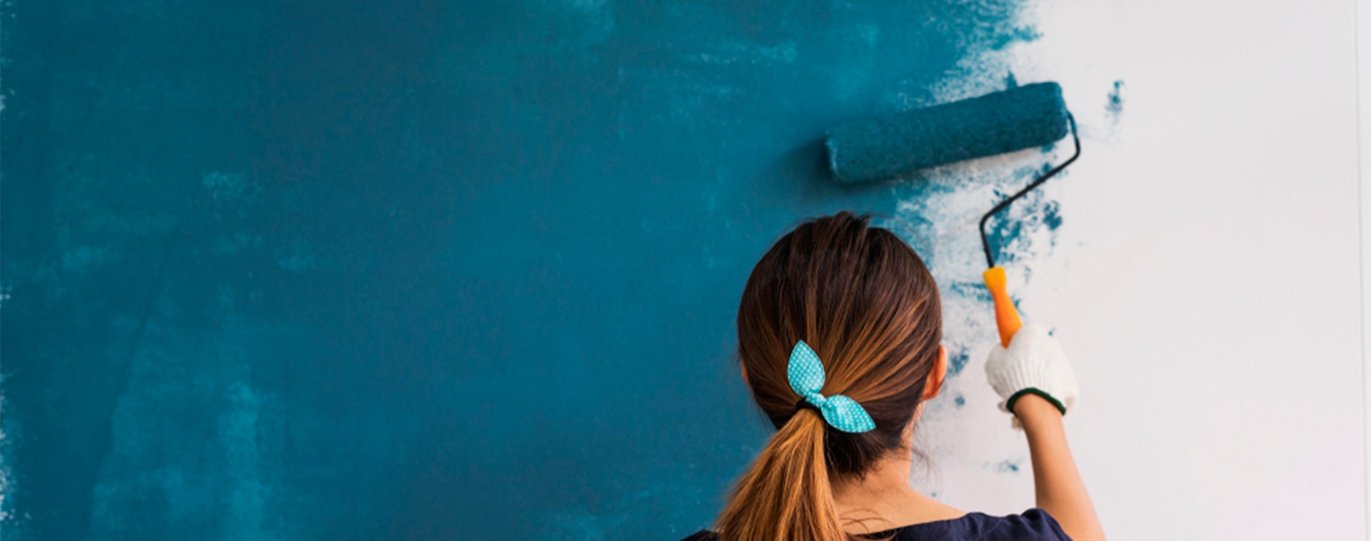 chica-de-espalda-pintando-pared-azul-con-rodillo